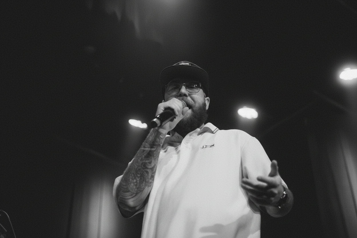 Jono singing into a microphone on stage with warm lighting